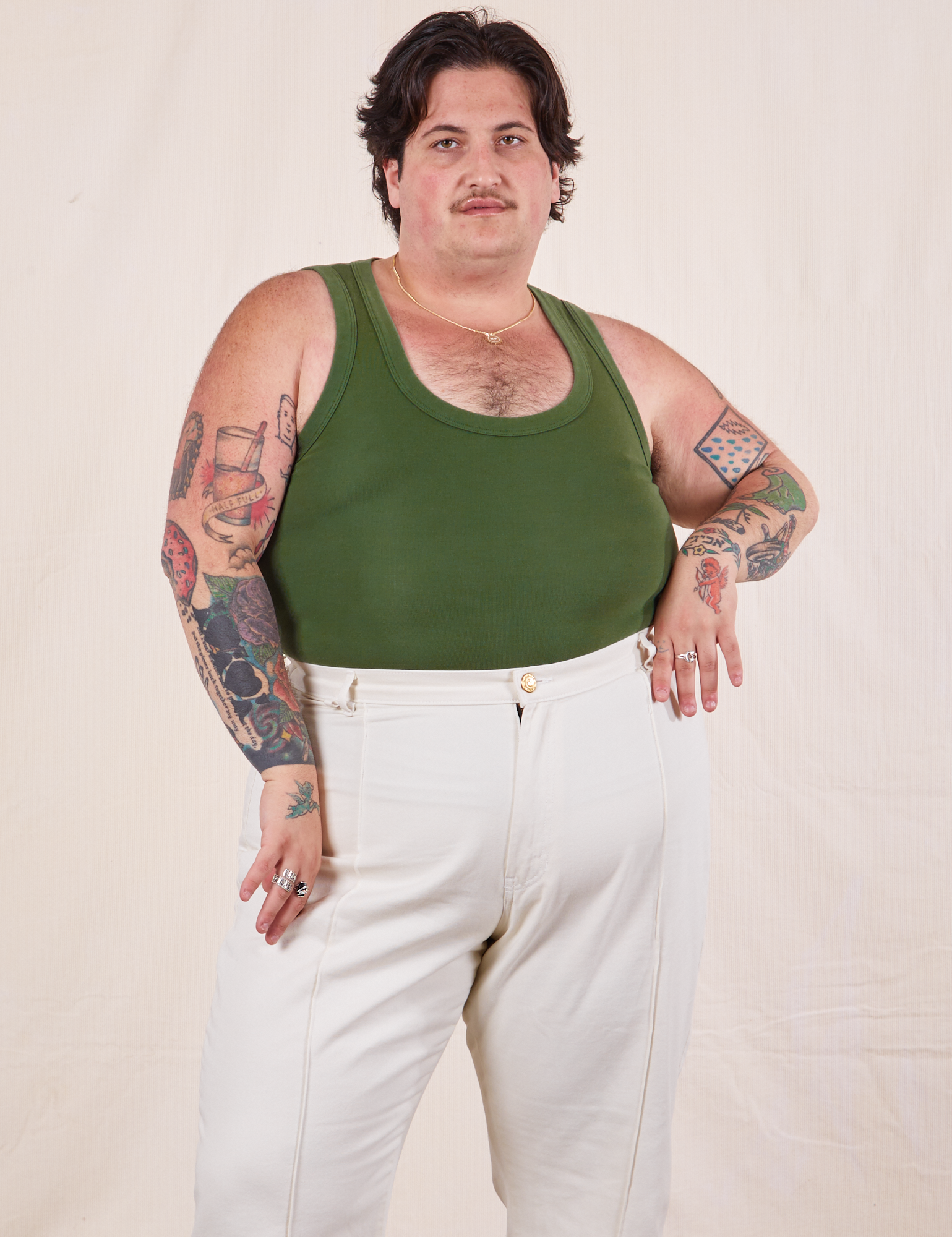 Sam is wearing XL Tank Top in Dark Emerald Green paired with vintage tee off-white Western Pants