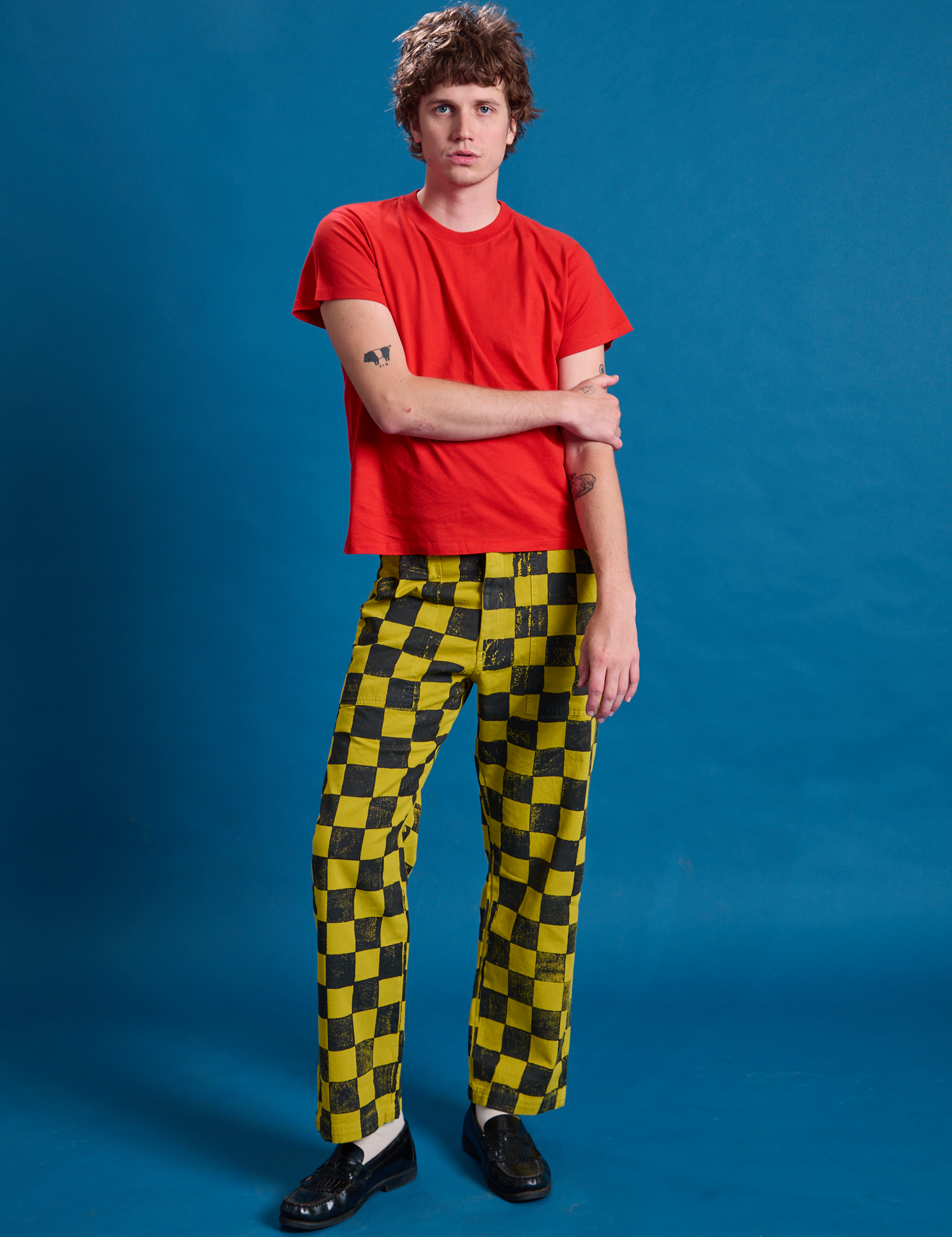 Quinn is 6'3" and wearing M Checkerboard Work Pants in Yellow/Black paired with a mustang red Organic Vintage Tee