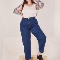 Sydney is 5'9" and wearing M Denim Trouser Jeans in Dark Wash paired with vintage off-white Tank Top