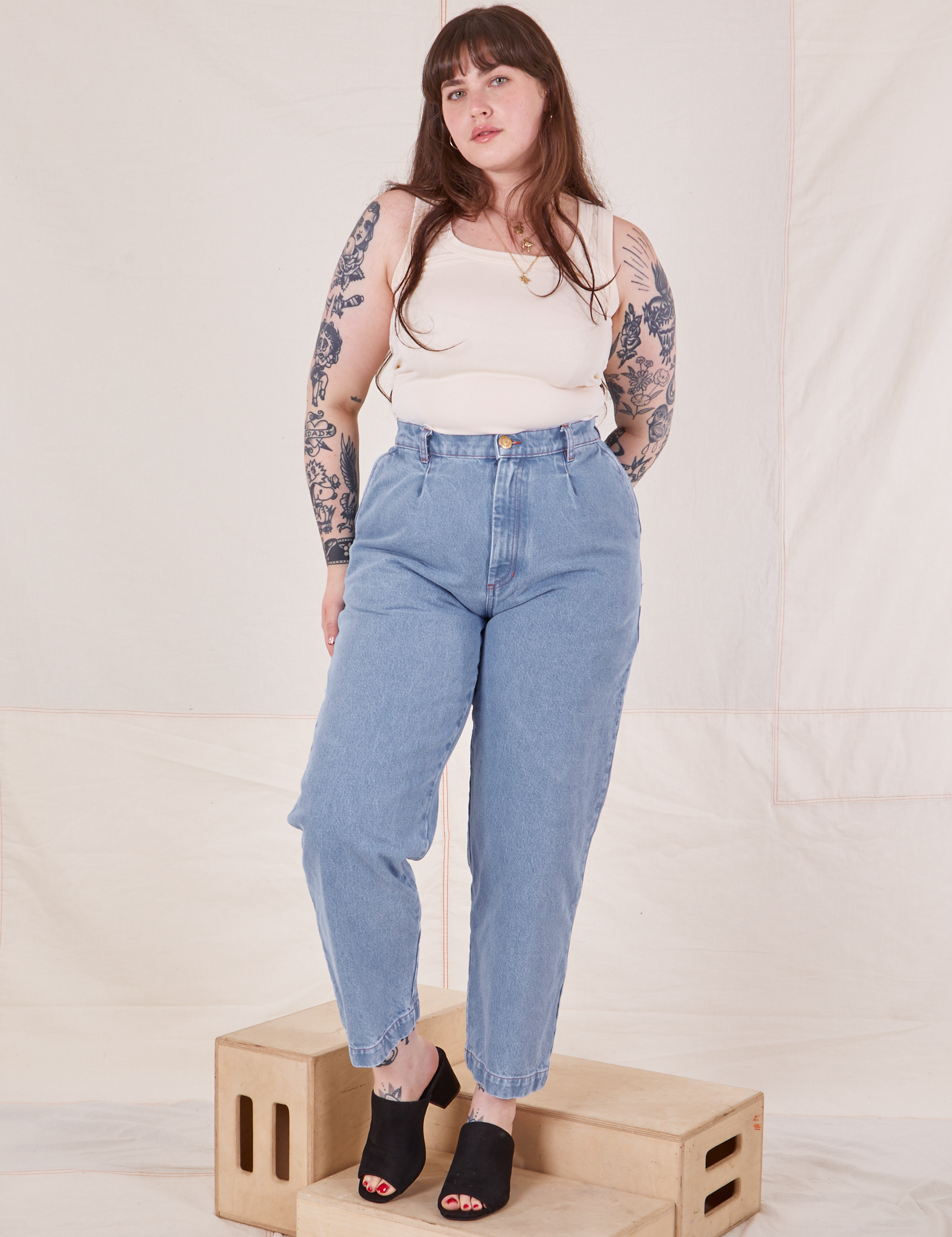 Sydney is 5&#39;9&quot; and wearing M Denim Trouser Jeans in Light Wash paired with vintage off-white Tank Top
