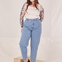 Sydney is 5'9" and wearing M Denim Trouser Jeans in Light Wash paired with vintage off-white Tank Top