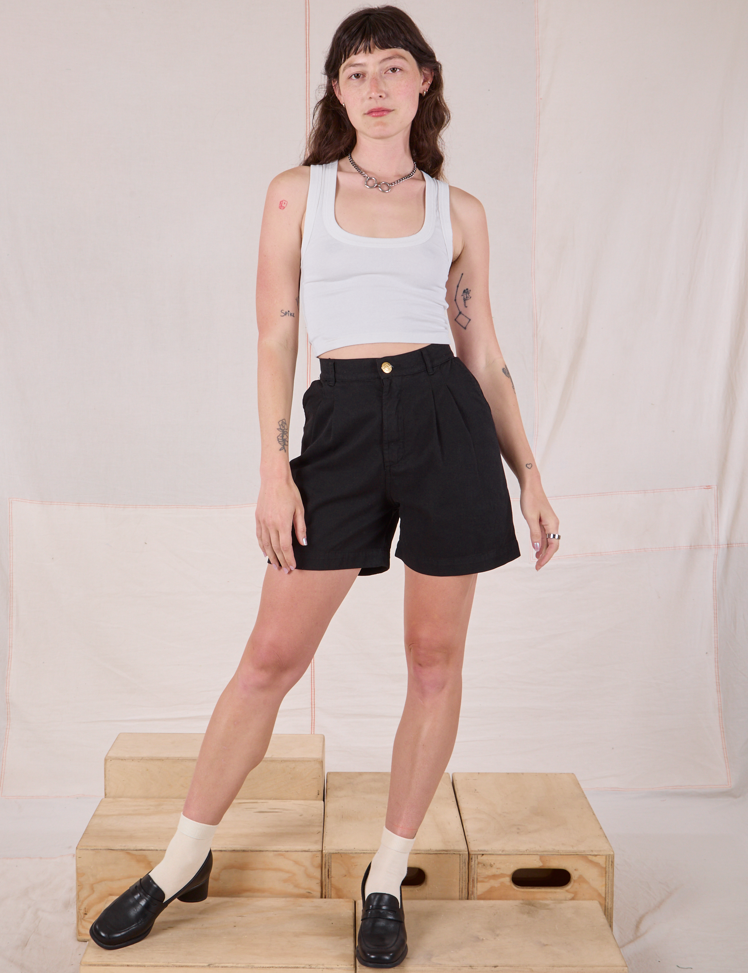 Alex is 5’8” and wearing XXS Trouser Shorts in Basic Black paired with a Cropped Tank in vintage tee off-white