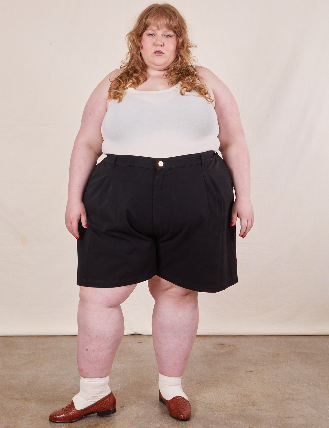Catie is 5'11" and wearing 4XL Trouser Shorts in Basic Black paired with a vintage off-white Tank Top