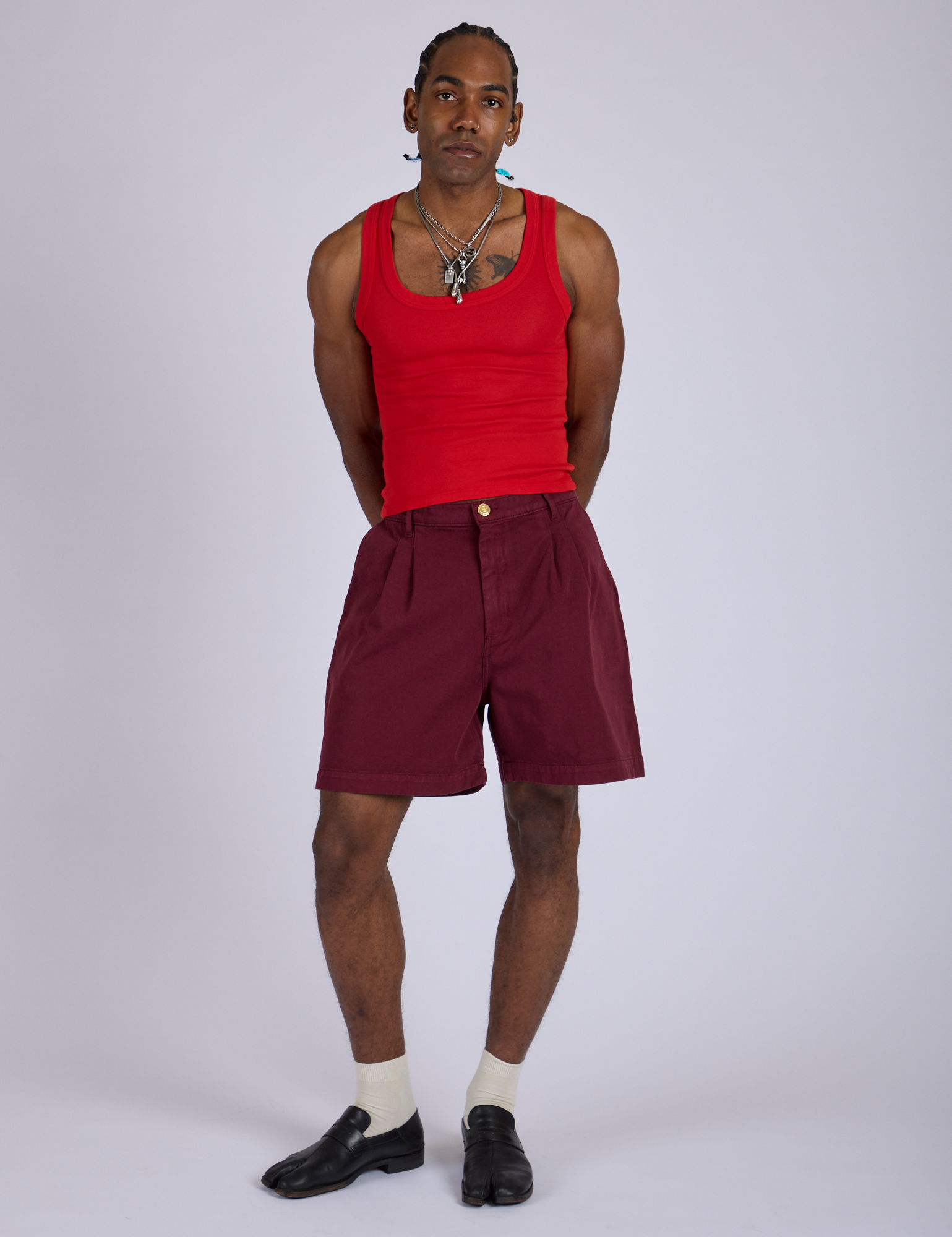 Jerrod is 6’3” and wearing M Pleated Trouser Shorts in Red Wine paired with mustang red Cropped Tank