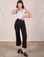 Alex is 5'8" and wearing XS Western Pants in Basic Black paired with a Cami in vintage tee off-white