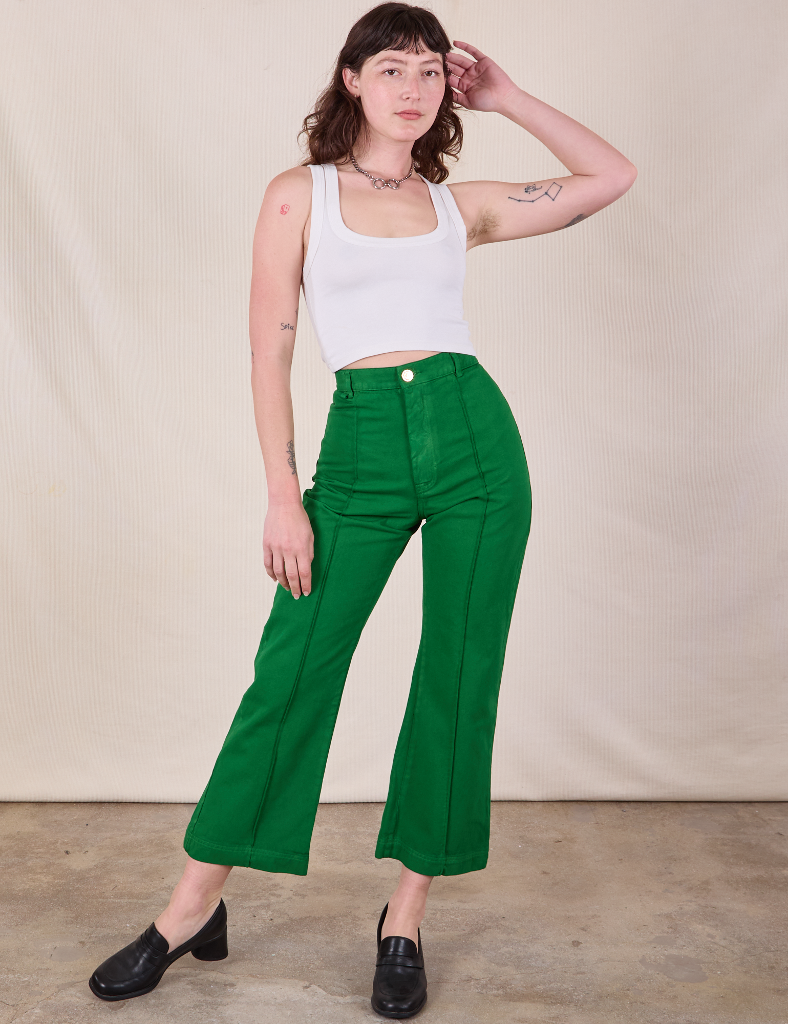 Alex is 5&#39;8&quot; and wearing XS Western Pants in Forest Green paired with a Cropped Tank in Vintage Tee Off-White