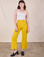 Alex is 5'8" and wearing XS Western Pants in Golden Yellow paired with a Cropped Cami in Vintage Tee Off-White