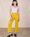 Alex is 5'8" and wearing XS Western Pants in Golden Yellow paired with a Cropped Cami in Vintage Tee Off-White