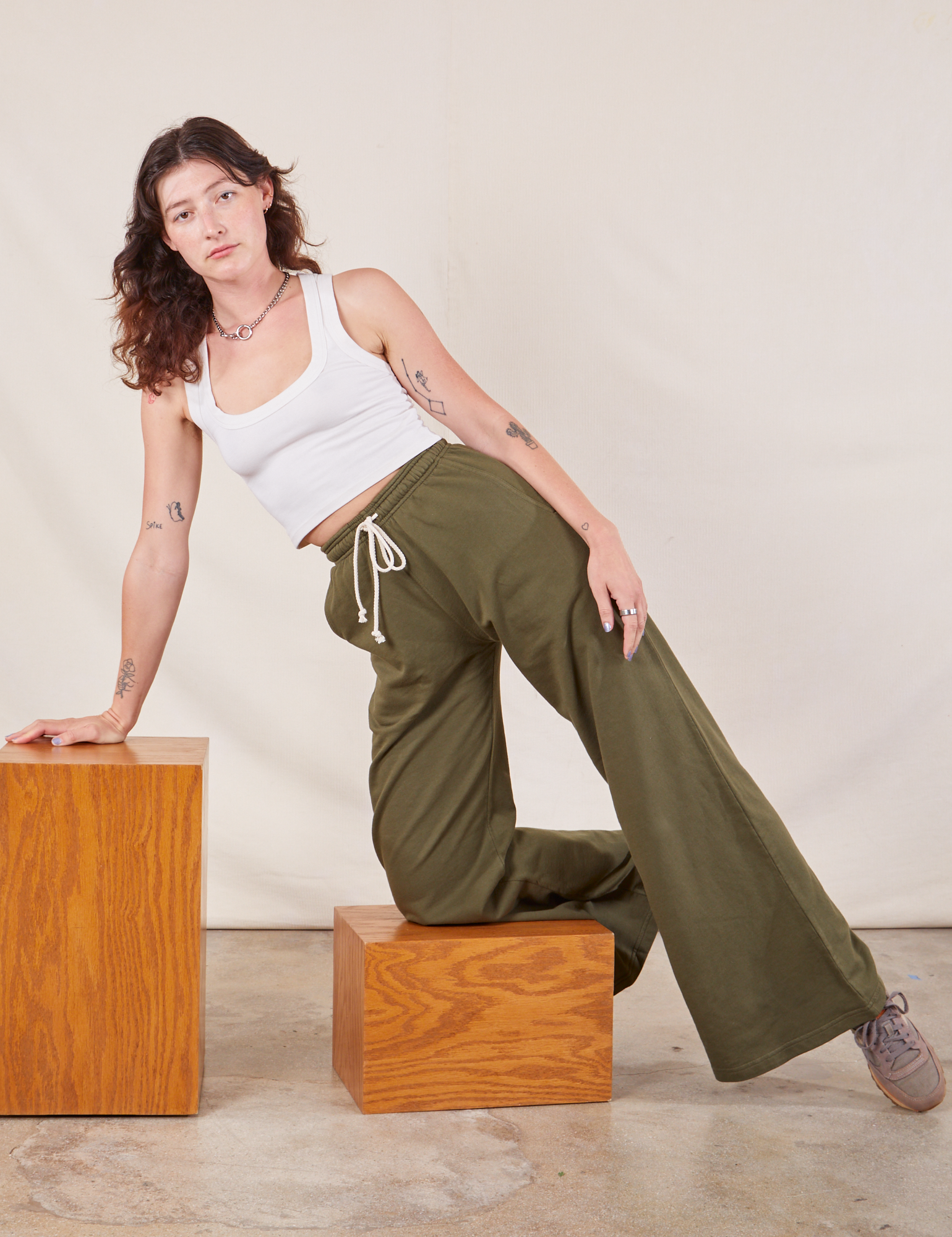 Alex is wearing Wide Leg Sweat Pants in Surplus Green and Cropped Tank in vintage tee off-white