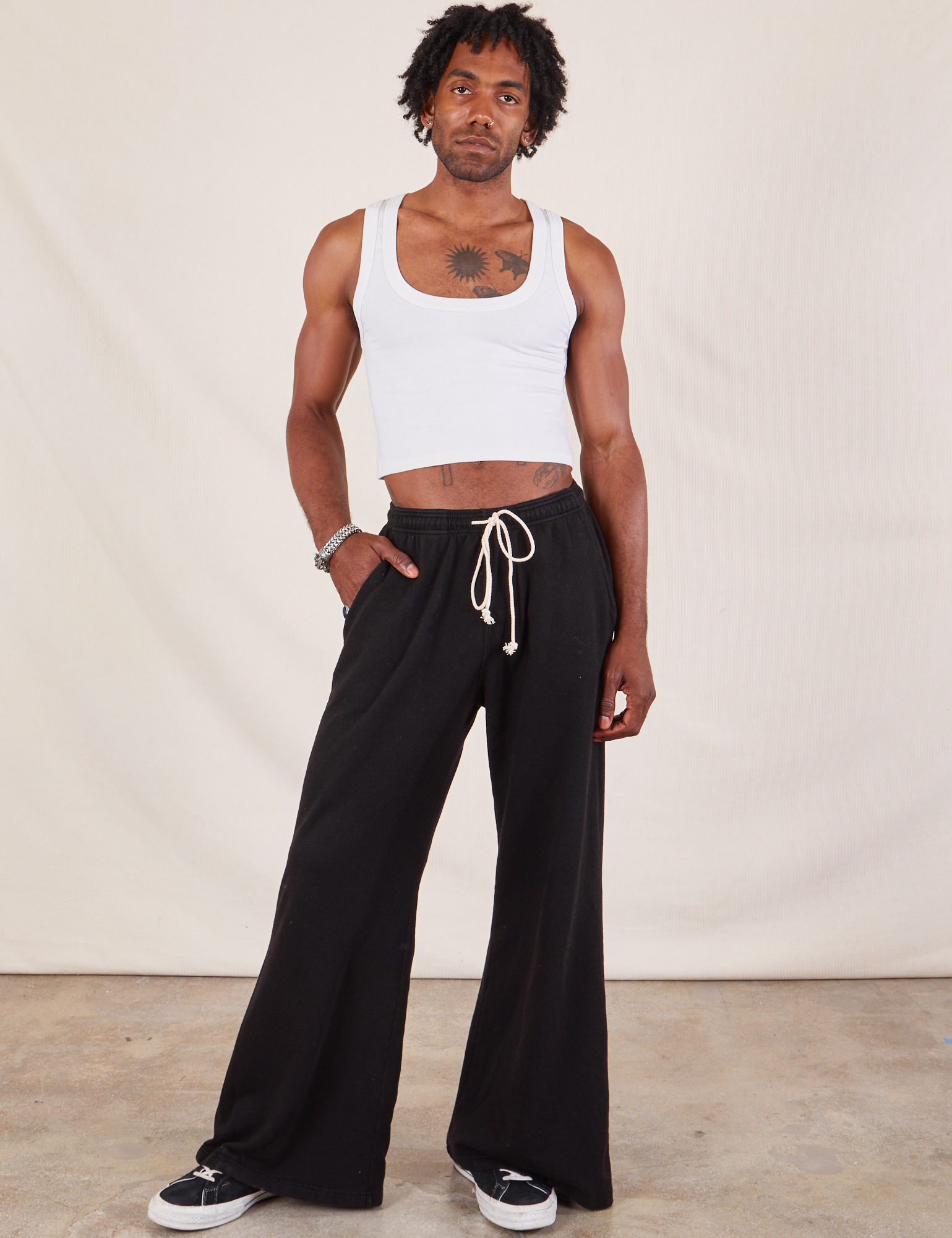 Jerrod is 6'3" and wearing S Wide Leg Sweat Pants in Basic Black paired with a Cropped Tank in vintage tee off-white