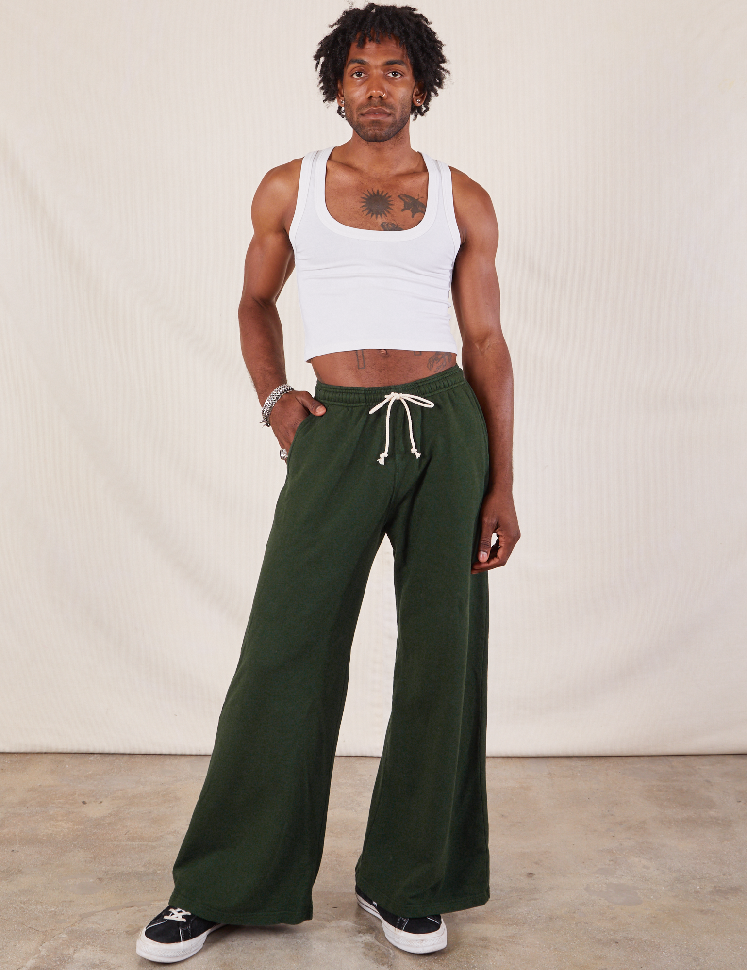 Jerrod is 6&#39;3&quot; and wearing S Wide Leg Sweat Pants in Swamp Green paired with Cropped Tank in vintage tee off-white