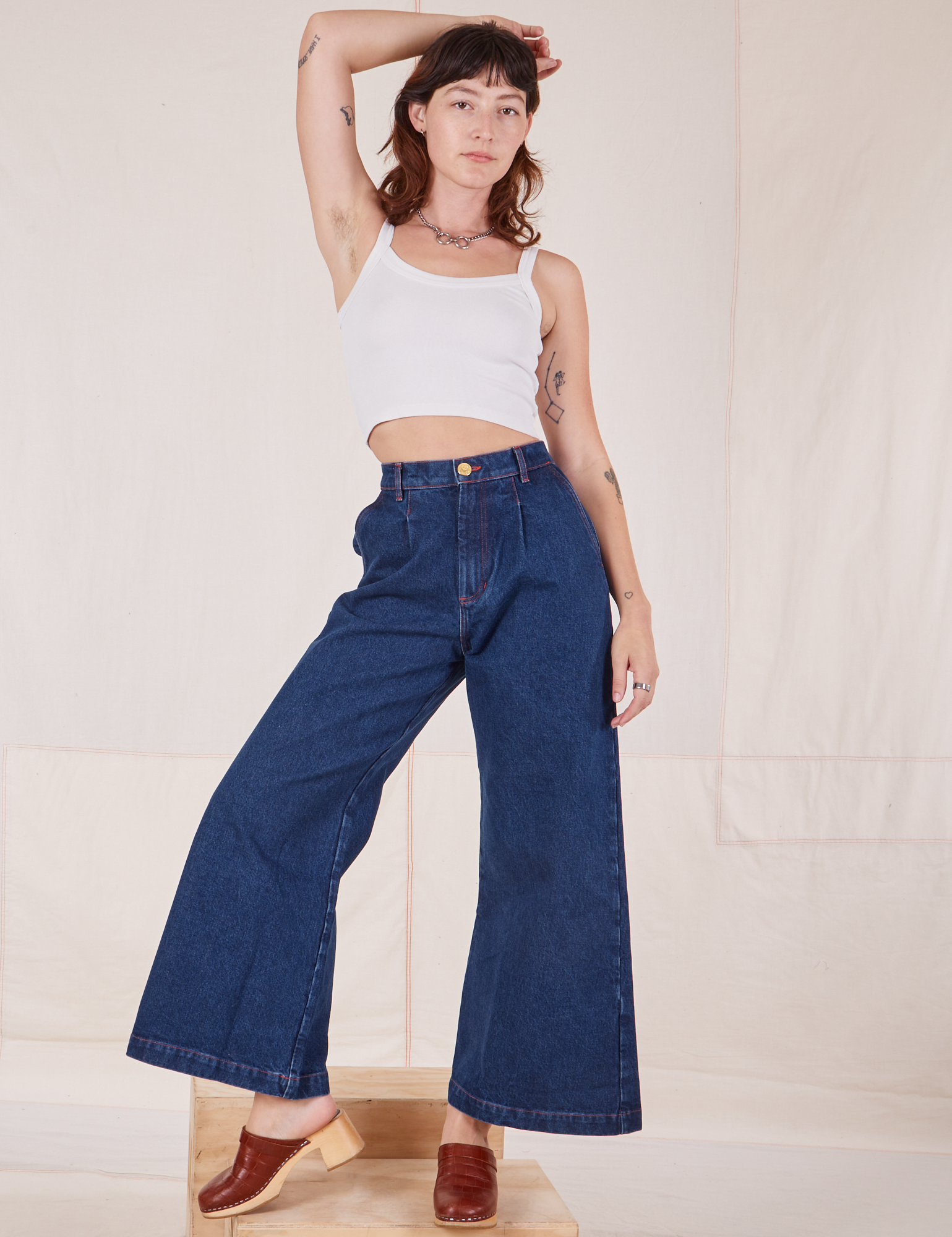 Alex is 5&#39;8&quot; and wearing XXS Indigo Wide Leg Trousers in Dark Wash paired with vintage off-white Cami