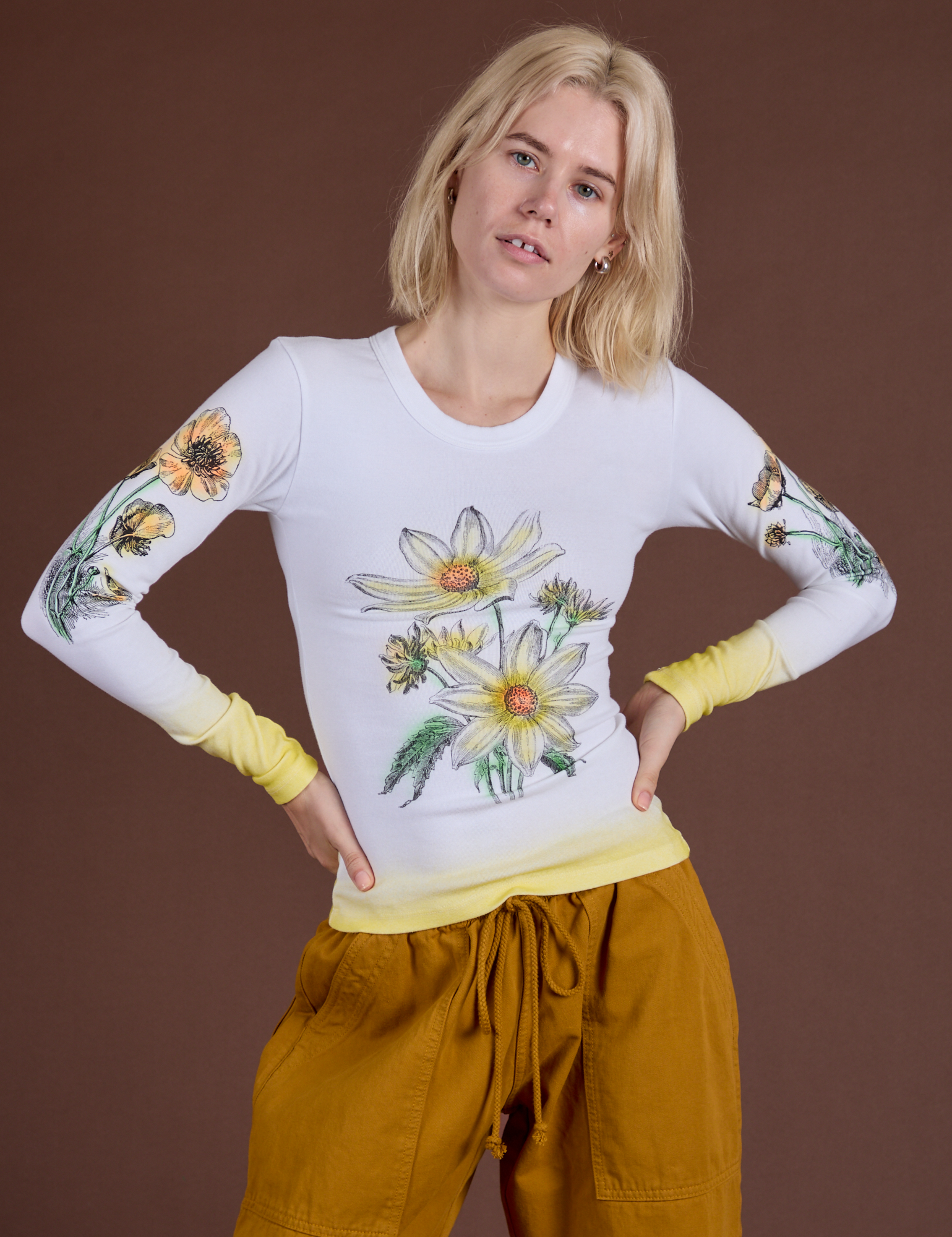 Madeline is 5’9” and wearing P Floral Long Sleeve Baby Tee in Yellow