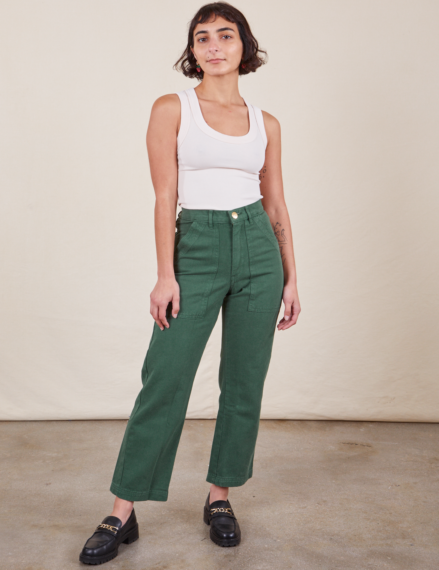 Soraya is 5&#39;2&quot; and wearing Petite XXS Work Pants in Dark Emerald Green paired with vintage off-white Tank Top