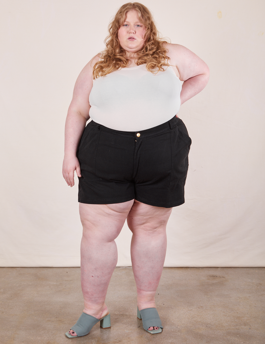 Catie is 5'11" and wearing size 5XL Classic Work Shorts in Basic Black paired with vintage off-white Tank Top