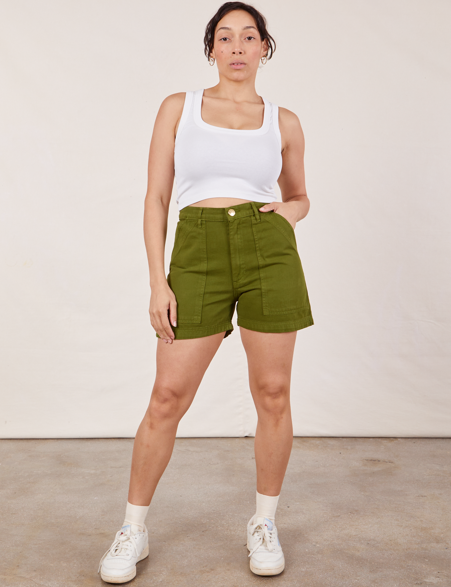 Tiara is 5’4” and wearing S Classic Work Shorts in Summer Olive paired with a Cropped Tank Top in vintage tee off-white