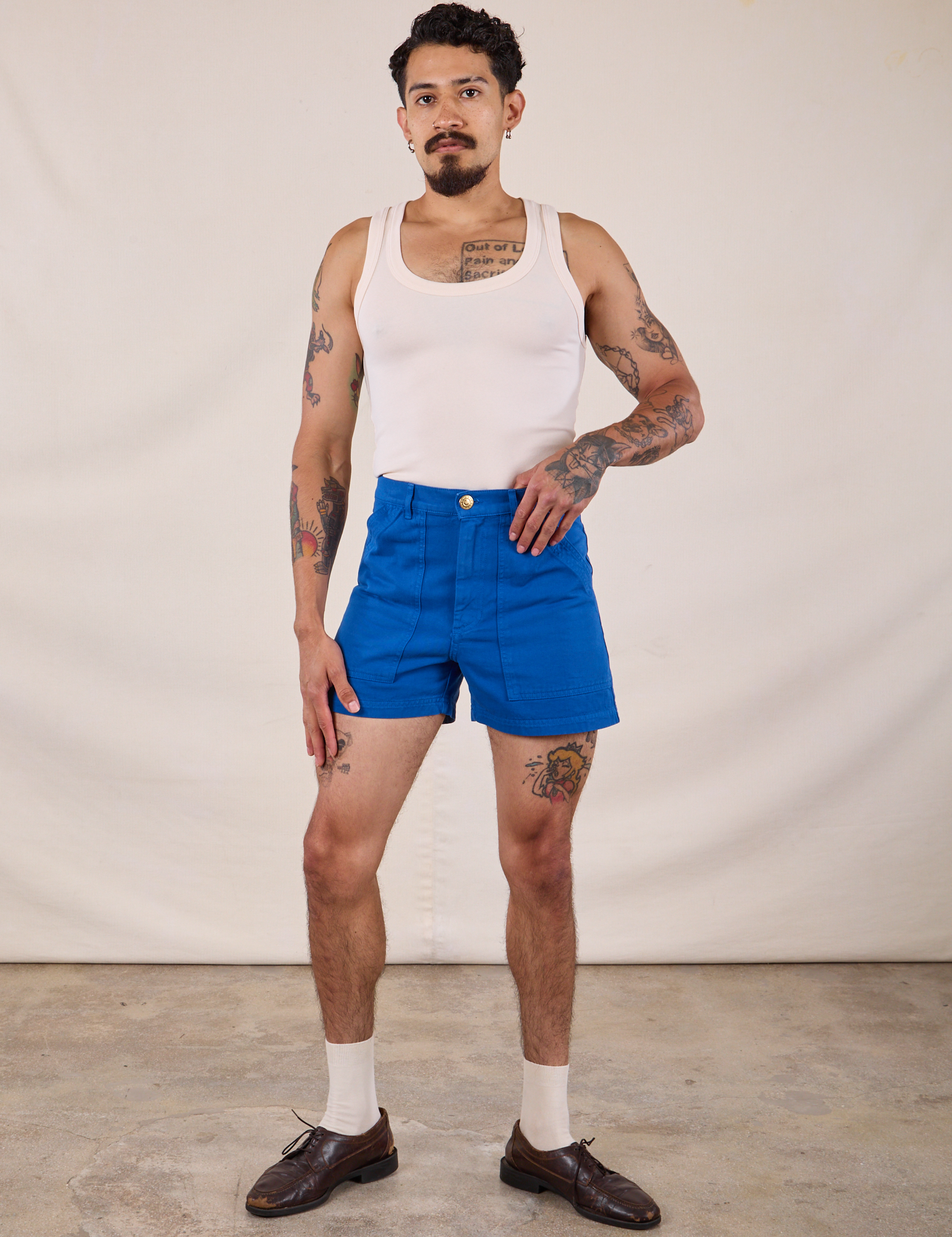 Jesse is 5’8” and wearing XS Classic Work Shorts in Royal Blue paired with a Tank Top in Vintage Tee Off-White