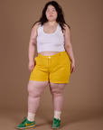 Ashley is 5’7” and wearing 1XL Classic Work Shorts in Sunshine Yellow paired with Vintage Tee White Cropped Tank