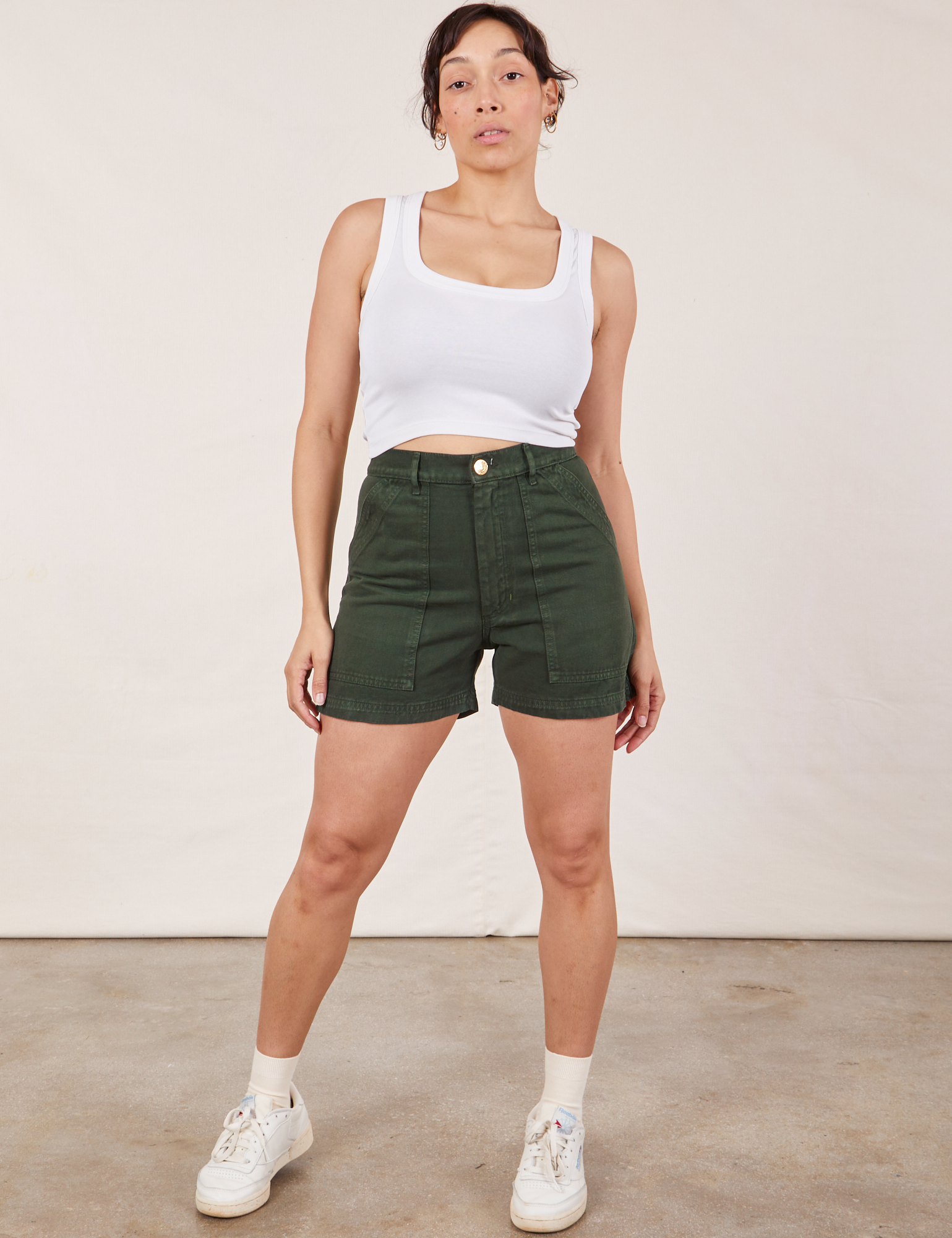 Tiara is 5’4” and wearing S Classic Work Shorts in Swamp Green paired with a Cropped Tank Top in vintage tee off-white