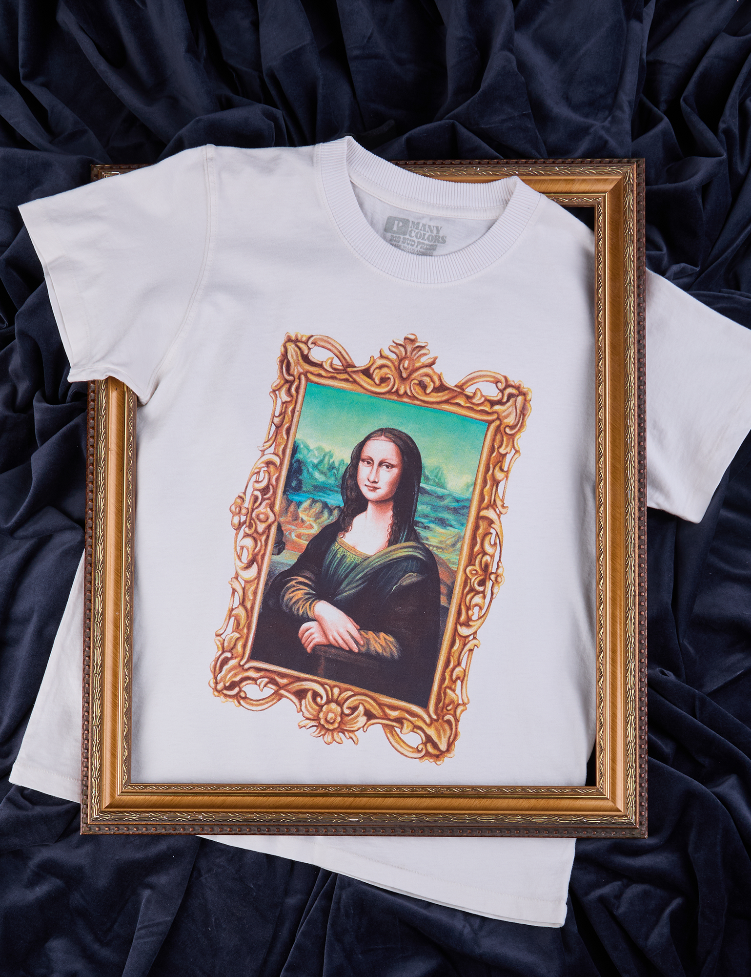 Masters Organic Tee in Mona Lisa centered in a gold ornate frame