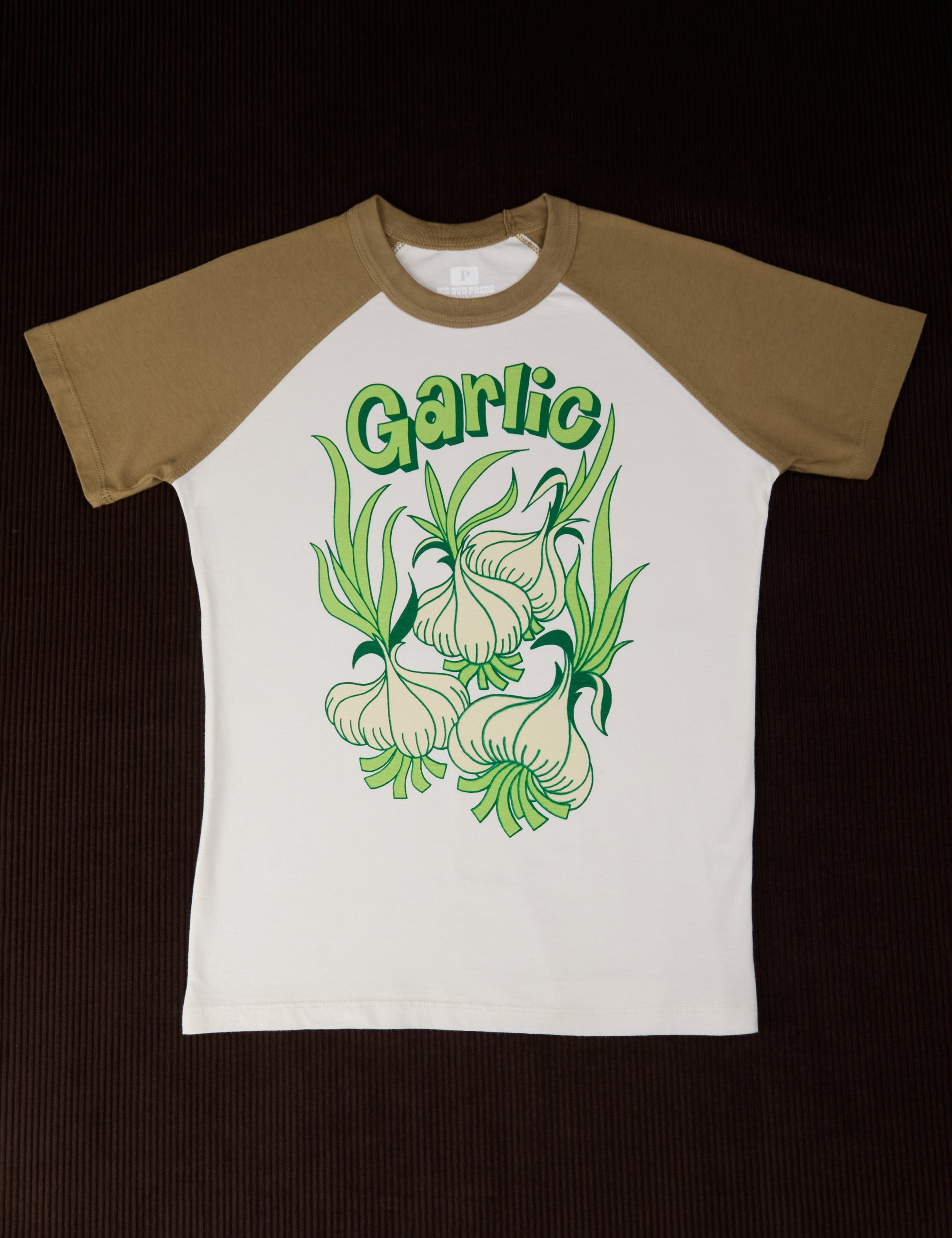 White tee body with green sleeves. Garlic illustration in middle of shirt