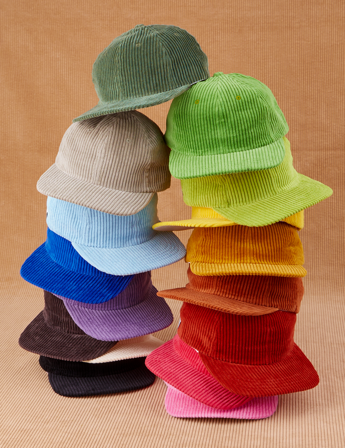 Dugout Corduroy Hat stacked on top of one another in a rainbow of hues