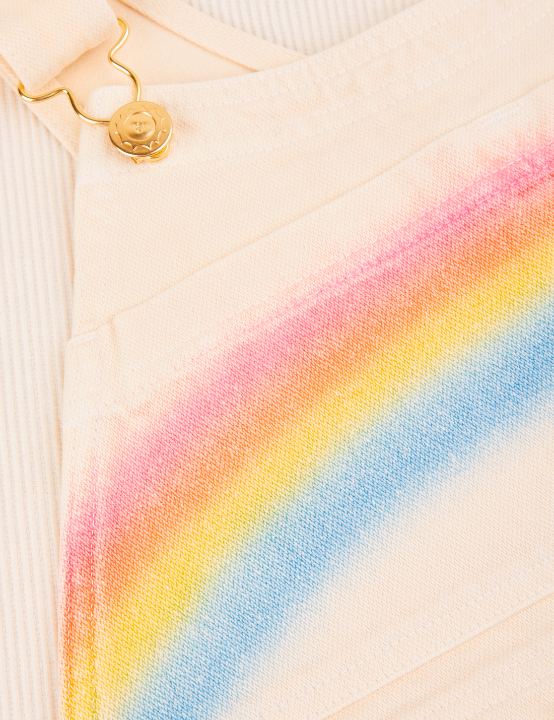Rainbow Overalls fabric detail. Close up of the airbrushed rainbow on the front.