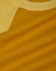 Fabric close up of the Mustard Yellow/Butter Raglan Tee