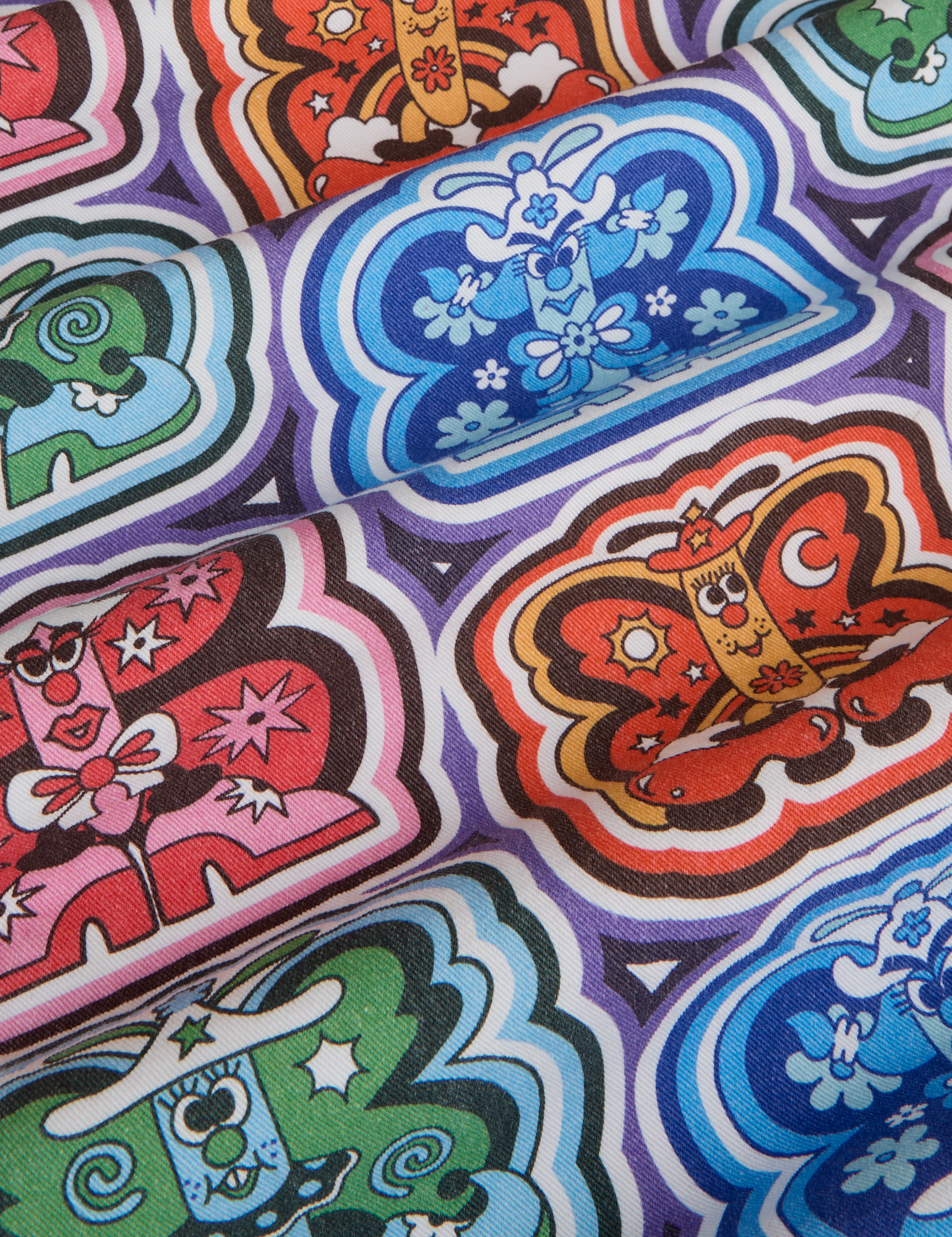 Butterfly Kaleidoscope Work Pants fabric detail close up. Illustrated butterflies in orange, red, blue and green.