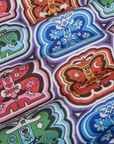 Butterfly Kaleidoscope Work Pants fabric detail close up. Illustrated butterflies in orange, red, blue and green.
