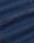 Carpenter Overalls in Dark Wash fabric detail close up. Contrast red top stitching