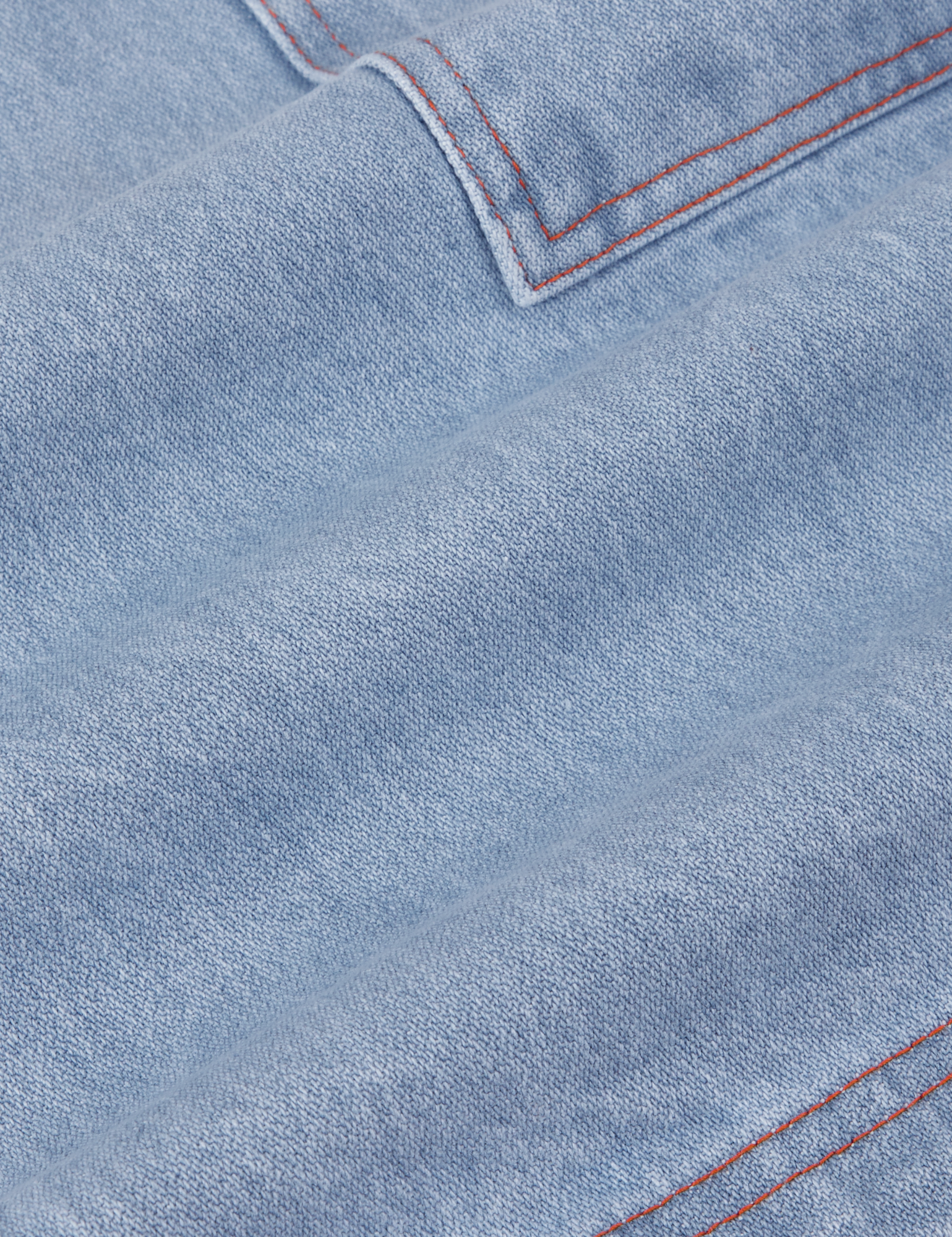 Carpenter Shorts in Light Wash fabric detail close up. Contrast orange stitching.