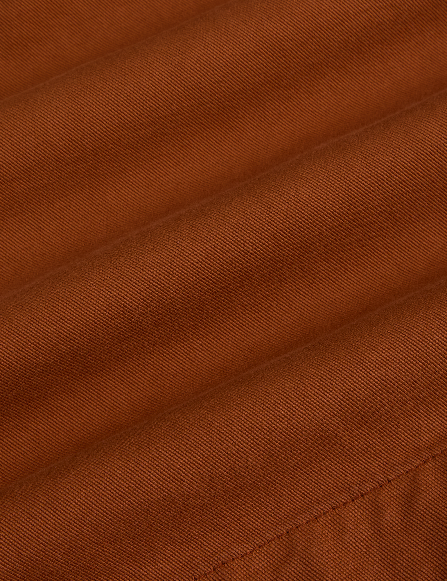 Pleated Trouser Shorts in Burnt Terracotta fabric detail close up