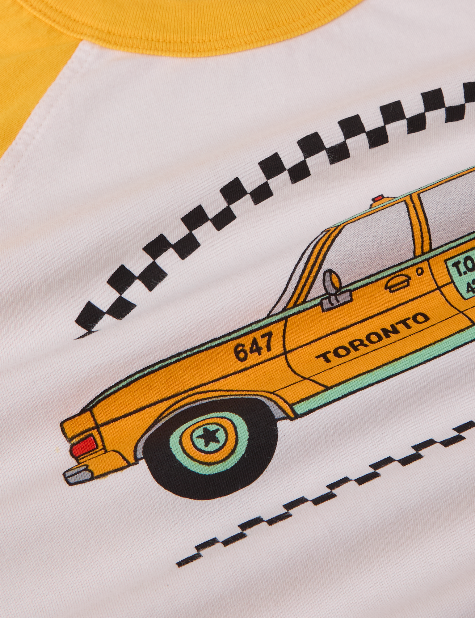 Taxi Raglan Tee in Toronto close up of yellow taxi graphic