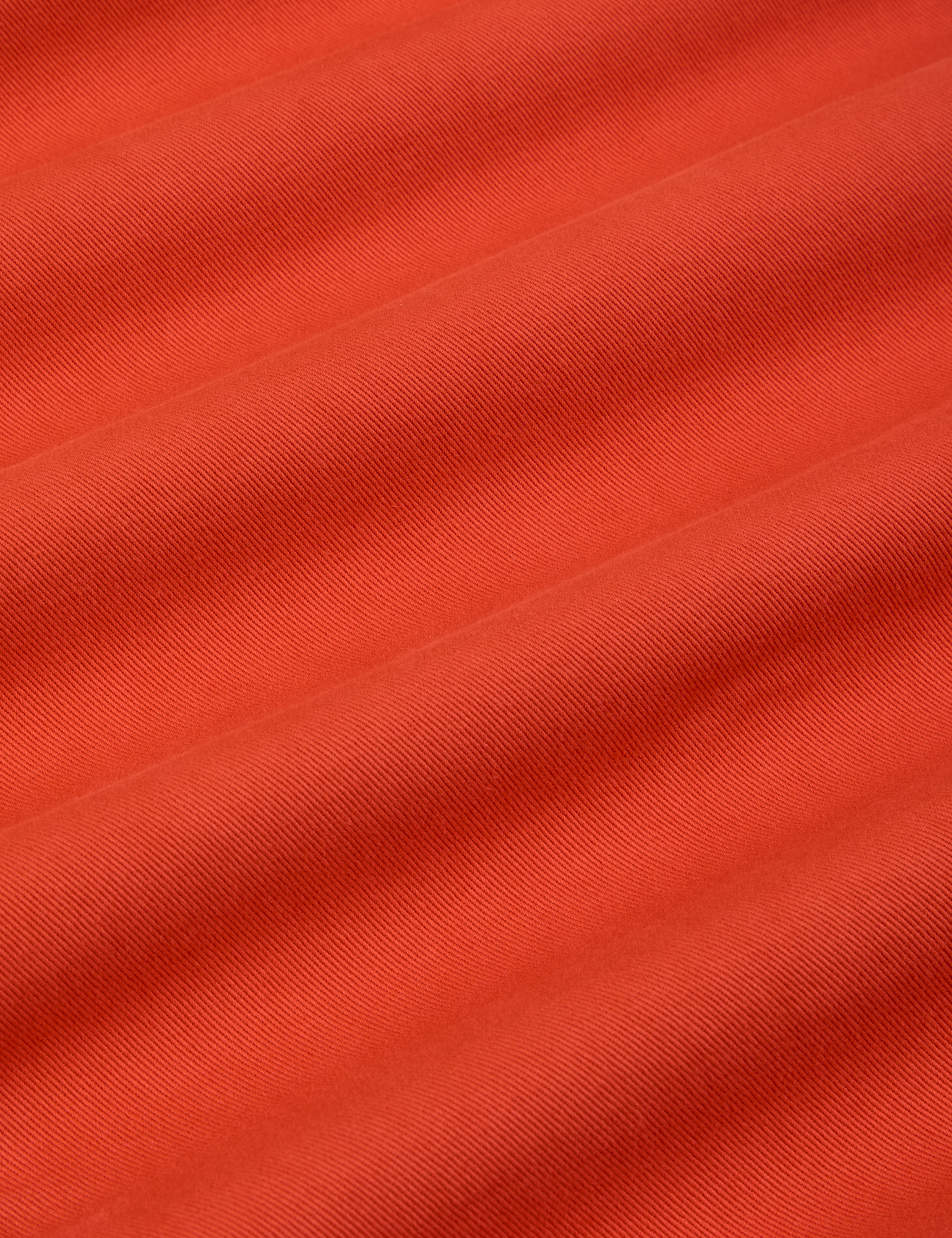 Mid-Rise Pleated Trousers in Chili Red fabric detail close up