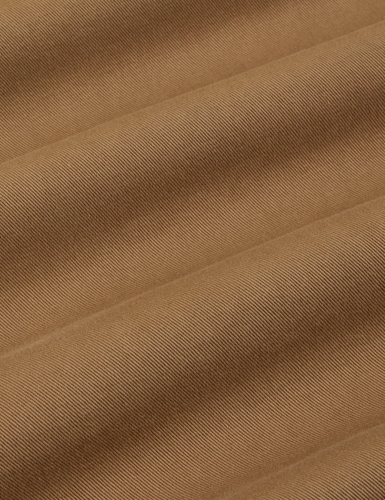 Mid-Rise Pleated Trousers in Desert Brown fabric detail close up