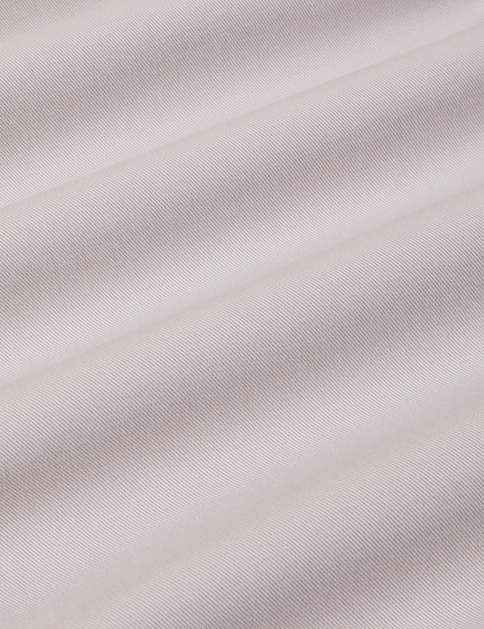 Mid-Rise Pleated Trousers in Stone White fabric detail close up