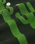 Paintstamped Work Pants in Cactus fabric detail close up. Green cactuses with white flowers. 