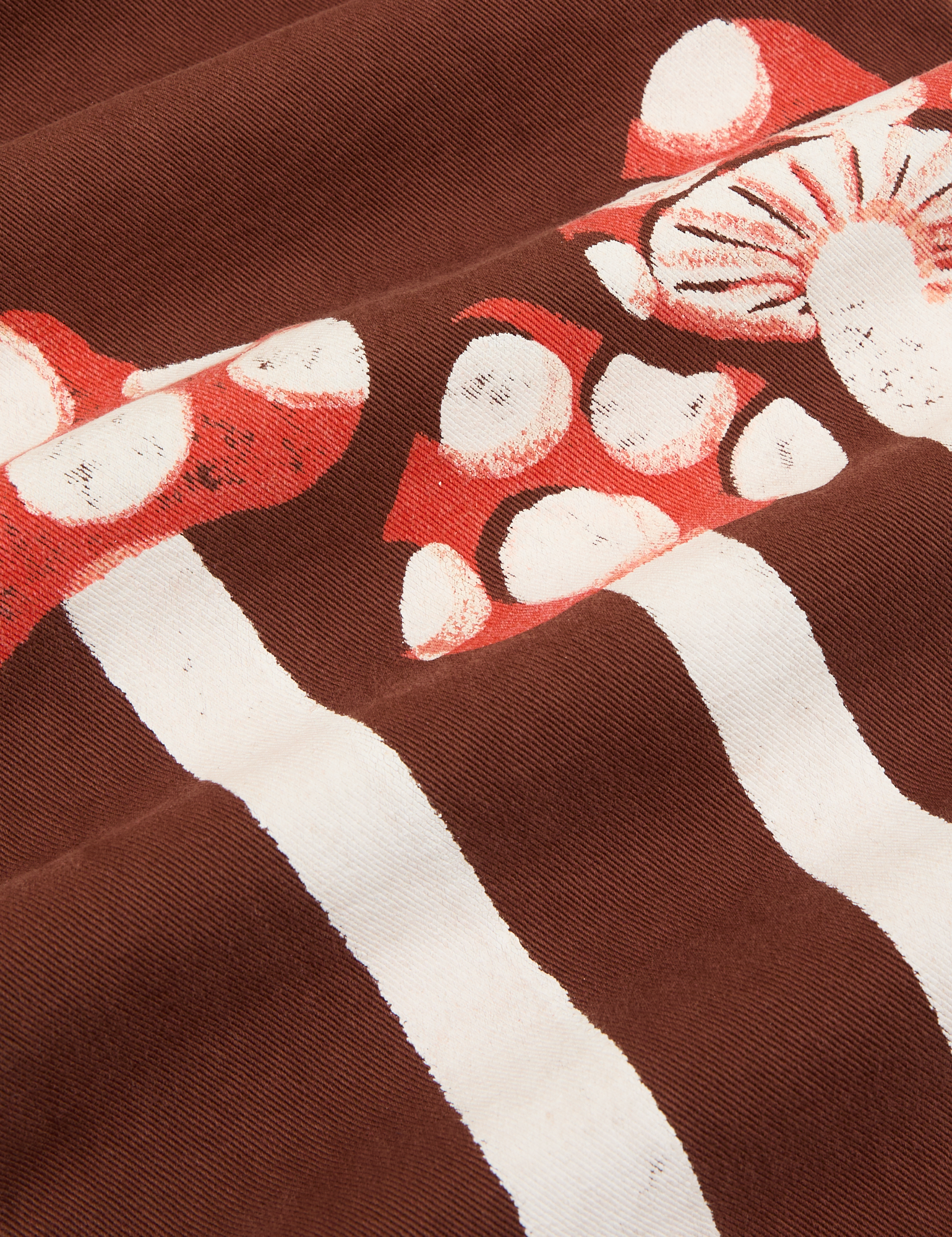 Paintstamped Work Pants in Mushroom fabric detail close up. Red and white mushrooms