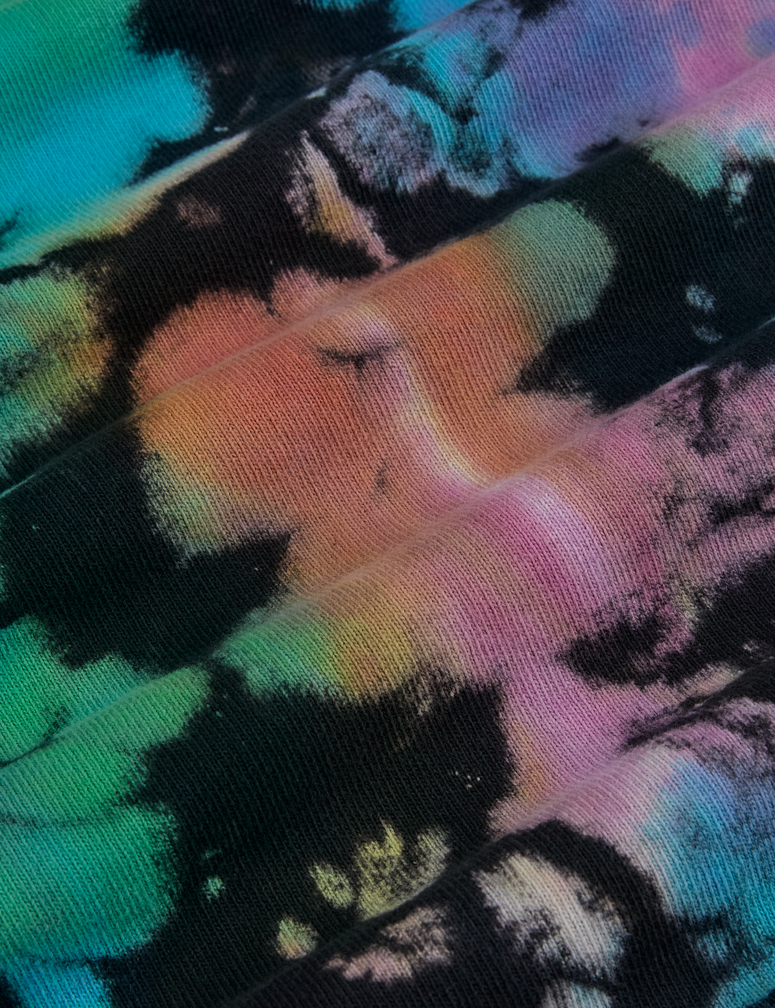 Magic Waters Long Sleeve Burly Tee in Rainbow fabric detail close up. Tie dyed in green, blue, purple, pink, orange and yellow.