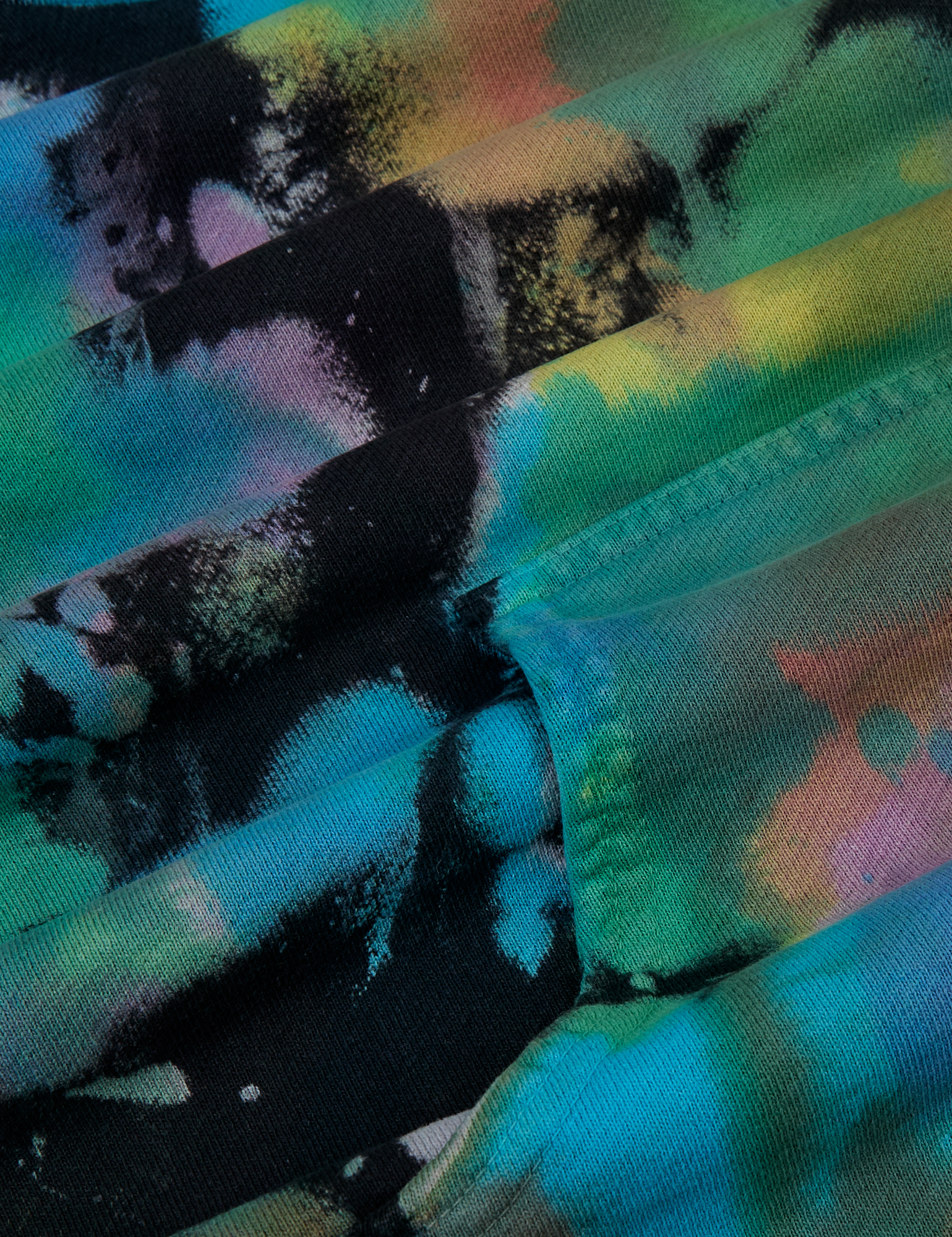 Oversized Hoodie in Rainbow Magic Waters fabric detail close up. Tie Dyed in green, blue, yellow, purple, pink and orange.