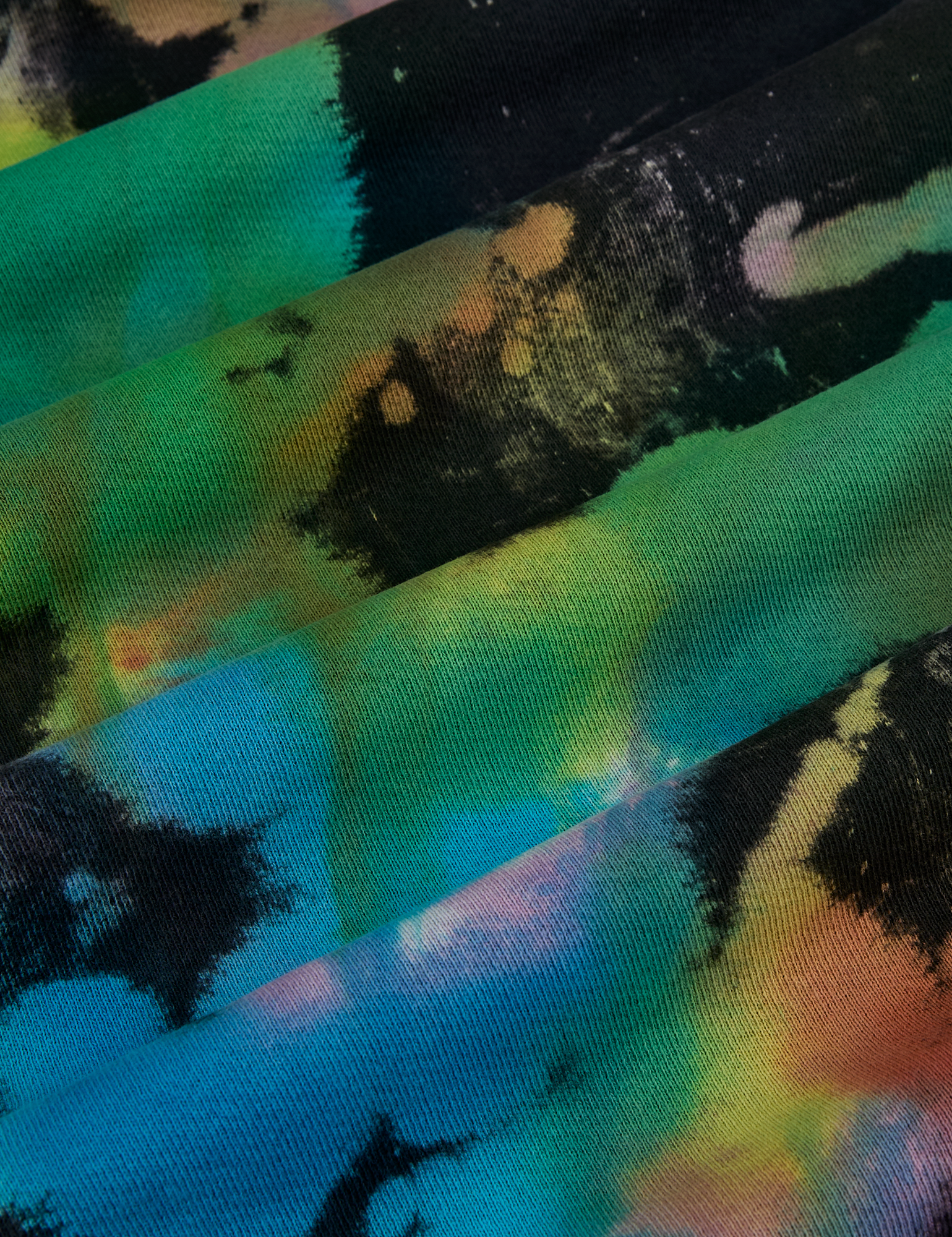 Tie Dyed Wide Leg Sweat Pants fabric detail close up. Tie dyed in green, blue, pink, orange, yellow.