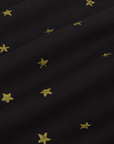 Star Bell Bottoms in Black fabric detail close up. Hand stamped yellow stars.