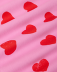 Paintstamped Heart Work Pants in Bubblegum Pink fabric detail close up. Red paintstamped hearts.