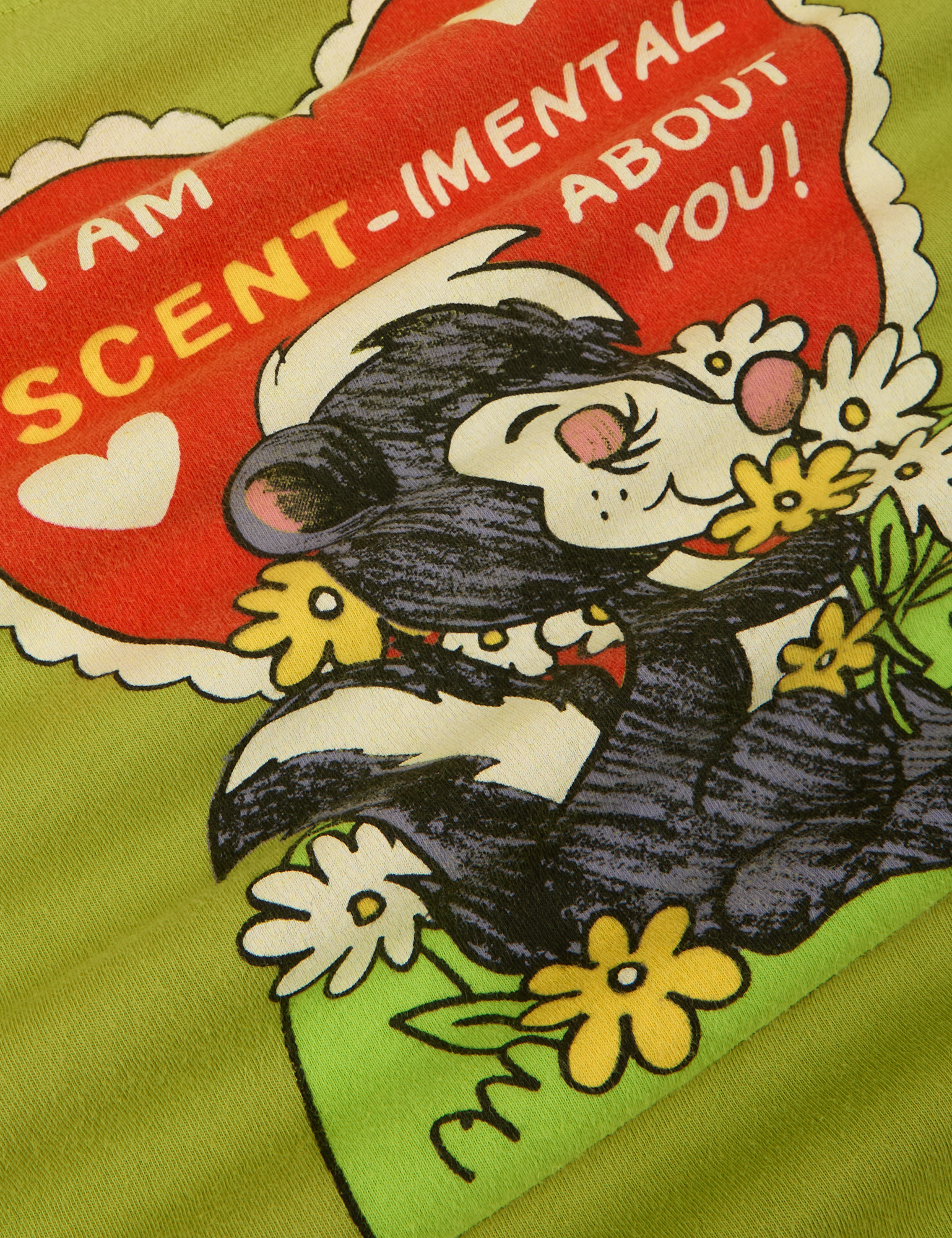 Skunky Organic Tee close up of Skunk, flowers and heart