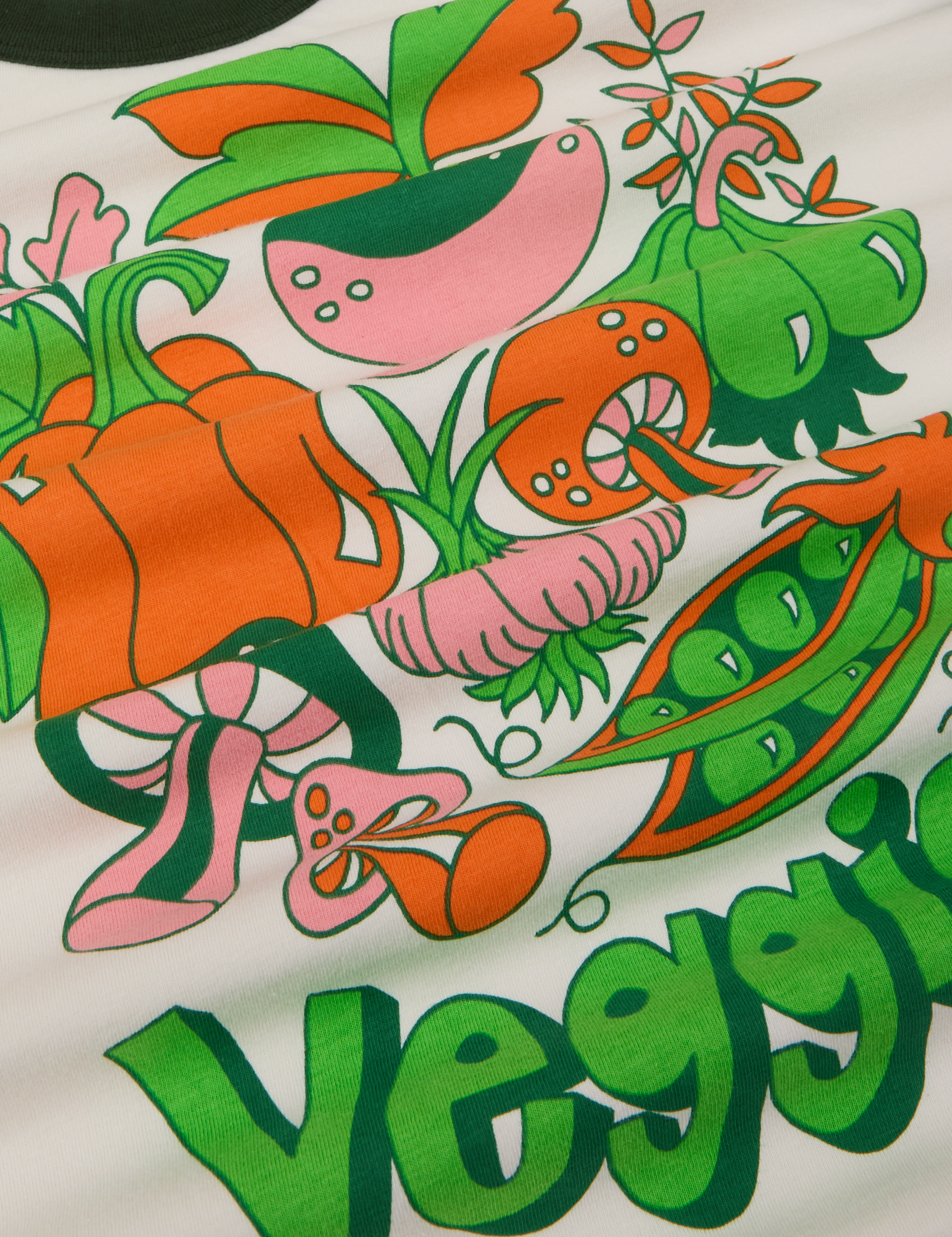 Close up of veggie tee featuring snap peas, mushrooms, garlic, and bell pepper