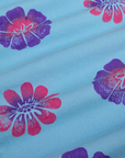 Floral Painted Work Pants in Blue fabric detail close up. Baby Blue Work Pants with paintstamped pink and purple flowers