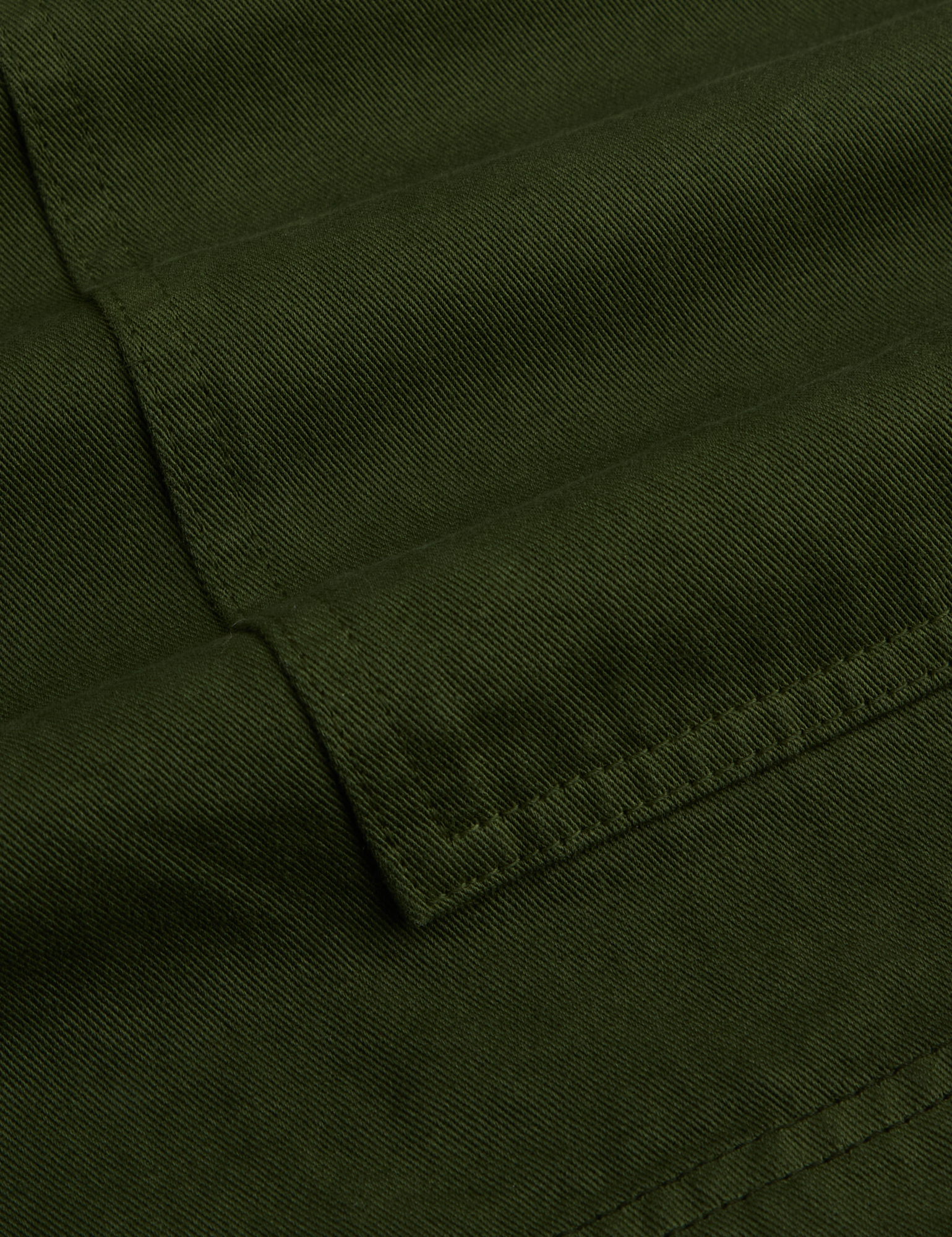 Close-up of dark green fabric with a visible seam
