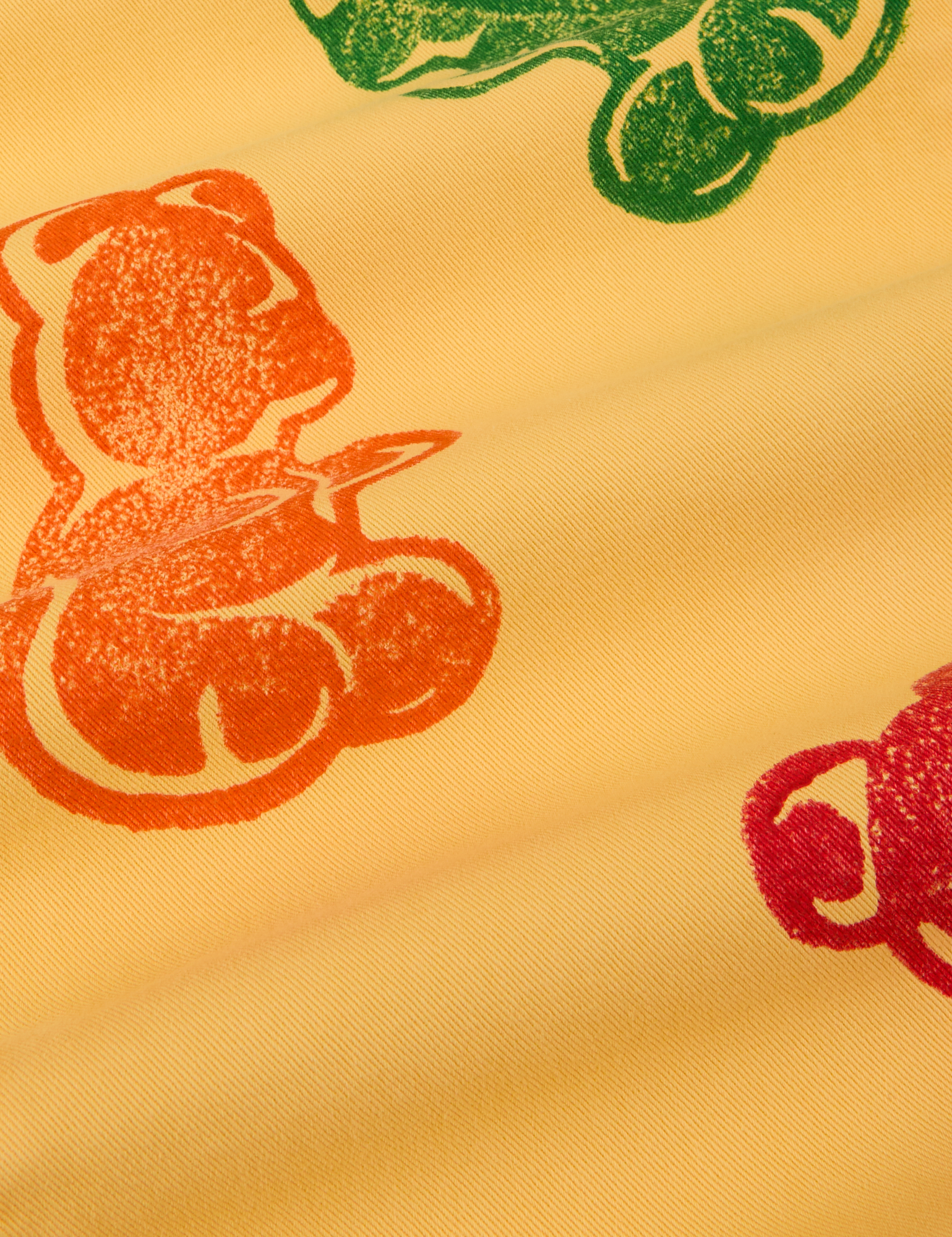 Close up of paintstamped gummy bears in orange, red and green on Work Pants