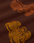 Close up of paintstamped gummy bears on yellow and orange on work pants